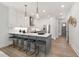 Bright kitchen featuring white cabinetry, stainless steel appliances, island with bar seating and stylish pendant lighting at 3922 Lost Fawn Ct, Raleigh, NC 27612