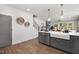 Open concept kitchen featuring white quartz countertops, grey cabinets, stainless steel dishwasher and farmhouse sink at 3922 Lost Fawn Ct, Raleigh, NC 27612