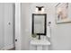 Contemporary powder room featuring a pedestal sink, black fixtures and decorative wall art at 3922 Lost Fawn Ct, Raleigh, NC 27612