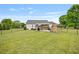 Expansive backyard with stone fireplace, patio, and well-manicured lawn surrounded by fencing at 40 Senter Farm Ct, Fuquay Varina, NC 27526