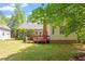Spacious backyard featuring a wood deck, a well-maintained lawn, and mature trees at 4012 Graham Newton Rd, Raleigh, NC 27606