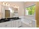 Bathroom with double sinks, marble counters, soaking tub, and walk-in shower at 4012 Graham Newton Rd, Raleigh, NC 27606