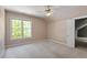 Cozy bedroom featuring neutral walls, carpet, a ceiling fan, and a large window with green outdoor views at 4012 Graham Newton Rd, Raleigh, NC 27606