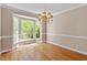 Bright dining room with hardwood floors, a large window, and a stylish chandelier at 4012 Graham Newton Rd, Raleigh, NC 27606