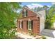 Side view of brick house featuring black shutters, green landscaping, and a two-car garage at 4012 Graham Newton Rd, Raleigh, NC 27606