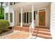 Inviting front porch with brick flooring and white columns, leading to an attractive front door at 4012 Graham Newton Rd, Raleigh, NC 27606