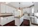 Kitchen with an island, white cabinets, updated appliances, and dark wood floors at 4012 Graham Newton Rd, Raleigh, NC 27606