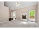 Inviting living room featuring a brick fireplace, a ceiling fan, and a large window overlooking the yard at 4012 Graham Newton Rd, Raleigh, NC 27606