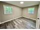 A well-lit bedroom is showcased, complete with gray-toned wood flooring and dual windows for natural light at 42 S 2Nd St, Roxboro, NC 27573