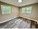 The light-filled bedroom showcases two windows and gray-toned floors, with views of the outdoors at 42 S 2Nd St, Roxboro, NC 27573