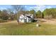 A quaint two-story home with back porch is nestled among trees on a large lot at 4208 Louisbury Rd, Wake Forest, NC 27587