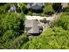 Aerial shot of the property showcasing lush landscaping, driveway, and outdoor seating areas at 4210 Falls River Ave, Raleigh, NC 27614