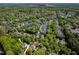Expansive aerial view of a residential neighborhood with mature trees, showcasing the homes in a lush setting at 4210 Falls River Ave, Raleigh, NC 27614