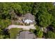 An aerial perspective of the residence features a sprawling lawn, patio, and verdant landscaping at 4210 Falls River Ave, Raleigh, NC 27614