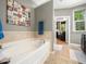 Bathroom with a large soaking tub and an artistic wall hanging at 4210 Falls River Ave, Raleigh, NC 27614