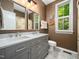 Stylish bathroom with a double sink vanity, patterned floor tiles, and a window with natural light at 4210 Falls River Ave, Raleigh, NC 27614