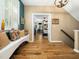 Inviting entryway with hardwood floors, a window bench, and a view into the main bedroom at 4210 Falls River Ave, Raleigh, NC 27614