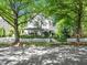 Attractive home with stone detailing, mature trees, and a white picket fence enhancing curb appeal at 4210 Falls River Ave, Raleigh, NC 27614