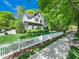 Charming two-story home featuring a manicured lawn, white picket fence, and lovely landscaping at 4210 Falls River Ave, Raleigh, NC 27614