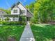 Charming two-story home with a stone entryway, manicured lawn, and lush landscaping at 4210 Falls River Ave, Raleigh, NC 27614