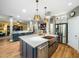 Open kitchen with a large island, modern appliances, and hardwood floors at 4210 Falls River Ave, Raleigh, NC 27614