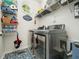 Well-organized laundry room featuring modern washer and dryer, storage shelves and patterned tile flooring at 4210 Falls River Ave, Raleigh, NC 27614