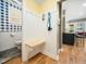 Mudroom features a built-in bench, hooks for storage, and entry to a blue-themed powder room at 4210 Falls River Ave, Raleigh, NC 27614