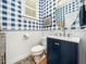 Charming powder room featuring blue checkered wallpaper, wainscoting, and a round mirror above the sink at 4210 Falls River Ave, Raleigh, NC 27614