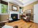 Cozy sitting room with a fireplace, hardwood floors, and natural light at 4210 Falls River Ave, Raleigh, NC 27614