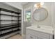 This updated bathroom features a modern vanity and generous closet shelving at 4318 Hunters Club Dr, Raleigh, NC 27606