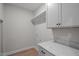 The laundry room features a grey wall color with white cabinets and a marbled white countertop at 45 Leisure Ln # 4, Louisburg, NC 27549