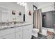 Modern bathroom features double vanity, granite countertops, shower and bath combination with grey tile at 4816 Heathshire Dr, Raleigh, NC 27616
