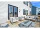 Spacious outdoor deck featuring modern white patio furniture, a fire pit and doors to the home's interior at 4816 Heathshire Dr, Raleigh, NC 27616