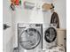 Well-equipped laundry room with side by side washer and dryer, storage shelves, and stylish tile floor at 4816 Heathshire Dr, Raleigh, NC 27616