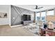 Bright living room with custom accent wall, wood floors, modern ceiling fan and plenty of natural light at 4816 Heathshire Dr, Raleigh, NC 27616