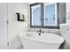 A clean, bright bathroom features a white soaking tub under a window for an elegant touch at 4816 Heathshire Dr, Raleigh, NC 27616