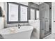 This bright, renovated bathroom boasts a large soaking tub, walk-in shower and classic finishes at 4816 Heathshire Dr, Raleigh, NC 27616