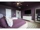 A tranquil main bedroom with dark purple accent wall and a ceiling fan at 4816 Heathshire Dr, Raleigh, NC 27616