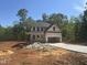 New home construction showing the exterior framework and concrete driveway on a sunny day at 5516 Jaeger Dr # 75, Graham, NC 27253