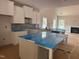 Spacious kitchen featuring white cabinets, a central island, and an open layout that flows into the living room with fireplace at 5516 Jaeger Dr # 75, Graham, NC 27253