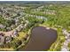 Aerial view of community showcasing beautiful homes nestled among trees and a serene lake at 602 Alden Bridge Dr, Cary, NC 27519