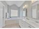 Bright bathroom featuring a double vanity, soaking tub, and neutral finishes at 602 Alden Bridge Dr, Cary, NC 27519