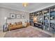 Cozy living room with a comfortable leather couch, built-in bookshelves and piano at 602 Alden Bridge Dr, Cary, NC 27519