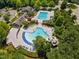 Aerial view of a large community pool area featuring a circular pool with slide, and a lap pool with surrounding landscaping at 602 Alden Bridge Dr, Cary, NC 27519