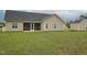 Backyard featuring a lawn, storage shed, screened-in porch, and tan siding at 63 Whistling Duck Way, Wendell, NC 27591