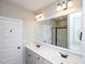 Bathroom featuring a double sink vanity with a large mirror, next to a door and shower at 63 Whistling Duck Way, Wendell, NC 27591