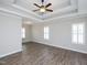 Spacious bedroom featuring tray ceilings, modern ceiling fan, and plank flooring at 63 Whistling Duck Way, Wendell, NC 27591