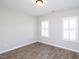 Bright bedroom features wood-look flooring and natural light from white shuttered windows at 63 Whistling Duck Way, Wendell, NC 27591