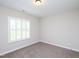 Well-lit bedroom with neutral walls, shuttered windows and modern carpet at 63 Whistling Duck Way, Wendell, NC 27591