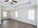 Large bedroom featuring plank flooring, tray ceilings, and recessed lighting at 63 Whistling Duck Way, Wendell, NC 27591